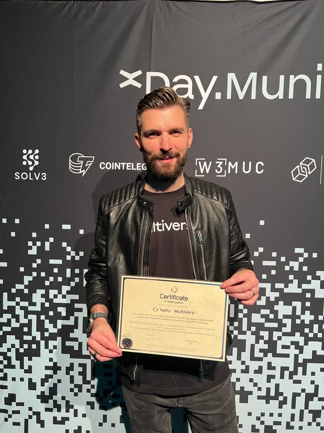 Beniamin Mincu holding the Certificate of Tokenization for his jacket.
